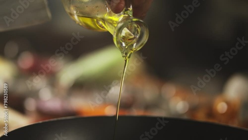 Chef pouring olive oil on a pan hot pan