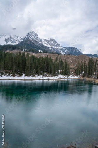 Lake Carezza in spring. Beautiful snowy mountain lake. Trentino Alto Adige, South Tyrol, Bolzano, Italy.