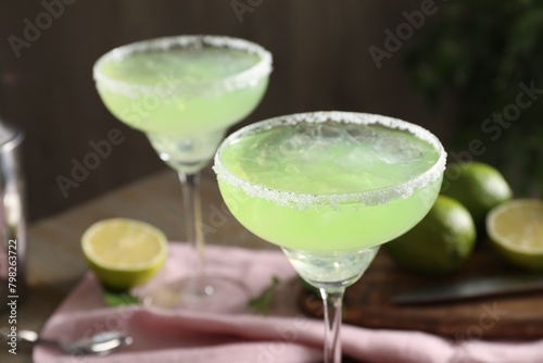 Delicious Margarita cocktail in glasses on table, closeup