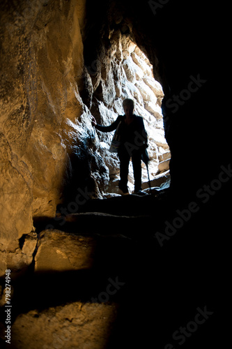 people walking in the tunnel, Woman, silhouette inside the Nuraghe of Santa Sabina. Silanus. Nuoro. Sardinia. Italy photo