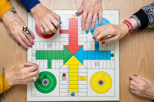 Group of unrecognizable senior woman playing the classic game Ludo or Parchis at nursing home. High quality photo