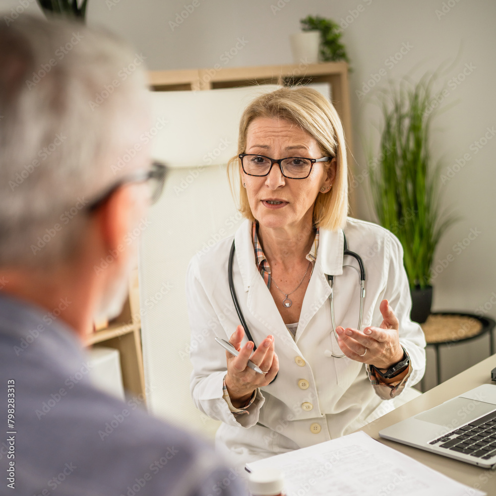 Fototapeta premium mature woman doctor communicate with mature man patient sit across her
