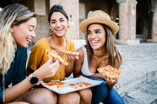 Photography EvotoHappy young tourist women friends having fun eating pizza during summer vac