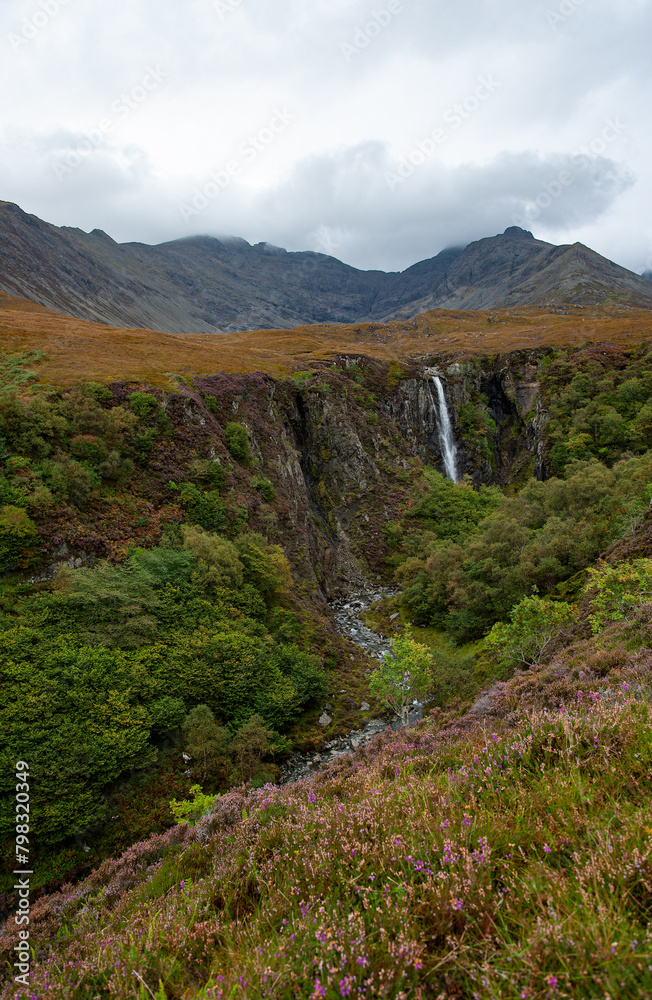 Smooth waters in a mountain river going down from with a lot of wild vegetation and grey rocks on a cloudy day Landscape photographed in Scotland Smooth waters in a mountain river going down from with a lot of wild vegetation and grey rocks on a cloudy day Landscape photographed in Scotland