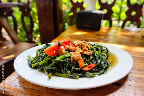 Tumis kangkung, an indonesian food. Stir fried water spinach or morning glory or kale photo