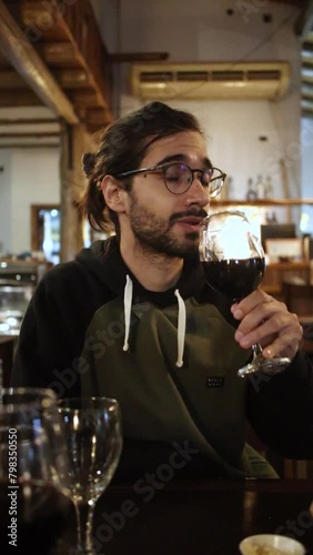 Young Man Savoring Wine Aroma with Pretentiousness in Restaurant - Sophisticated Dining Experience Concept