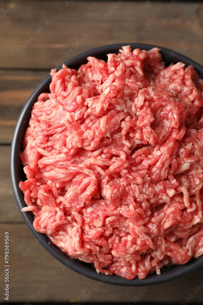 Raw ground meat in bowl on wooden table, top view Raw ground meat in bowl on wooden table, top view