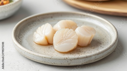 Scallops crafted from taro presented on a plain light background, arranged neatly. Explore the simplicity of taro crafted into scallop shapes, presented cleanly.