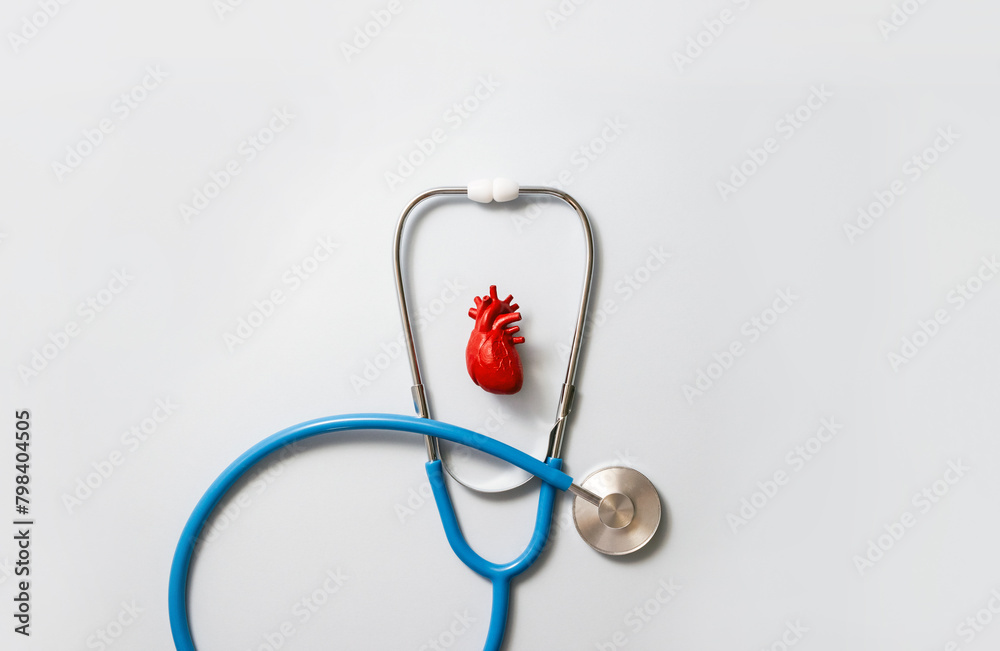 Heart model and blue stethoscope on gray background. Medical calendar for hospital or clinic. Selective focus, copy space Heart model and blue stethoscope on gray background. Medical calendar for hospital or clinic. Selective focus, copy space