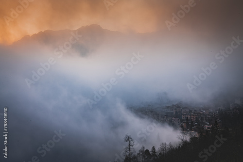 Orange sunrise sky at the rice terraces, dense fog and Duoyishu village, China