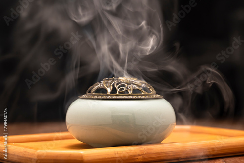 Incense burning in an incense burner on the table,with dark background. Religion concept. 