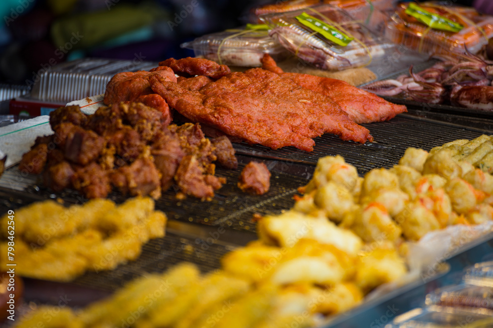 a variety of delicious fried foods displayed in metallic bowls at a street food stall a variety of delicious fried foods displayed in metallic bowls at a street food stall