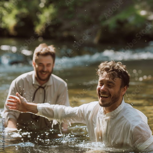 A man being baptized in the waters of a river. The person is happy about the religious rite. Adult person in his 30s