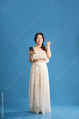 Portrait of asian girl posing on blue background  traveling in summer