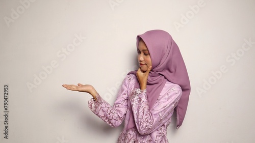 Indonesian teenage girls wearing kebaya and hijab gesture showing open palms