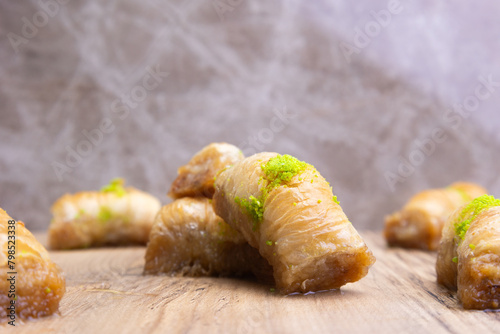 Turkish Baklava on plate with pistachio on top. Dessert on desk with light color background.