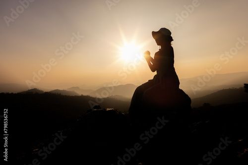 Silhouette of Person women  demonstrating their religious faith. women hand in prayer, expressing his religious faith in God through worship of Jesus Christ.turned to God in prayer.