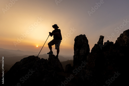 Silhouette of hiker standing on top mountain sunset background. Hiker men's hiking living healthy active lifestyle.