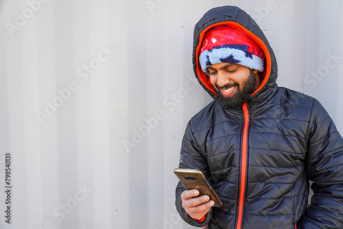 Cheerful young man looking at smartphone