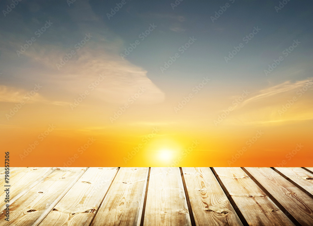 Wooden table on sky background and sunset light