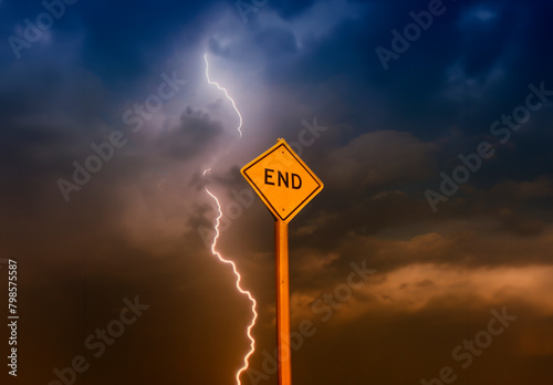 Yellow diamond shaped traffic sign with the word End written on it against a stormy cloudy sky with lightning