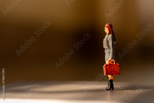 Miniature people ,  A businesswoman standing alone with a suitcase