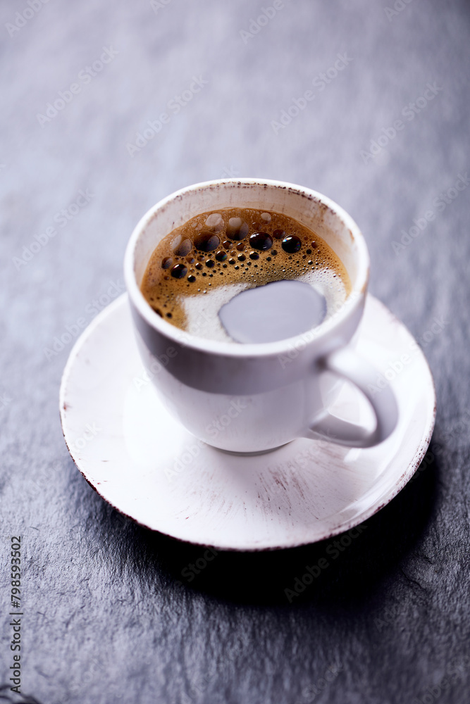 Cup of coffee on dark stone background. Close up. Copy space.

