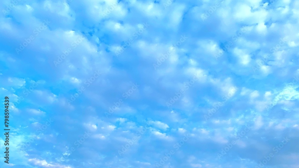 Fototapeta premium The background is a beautiful blue sky lined with clouds. The sun is setting.