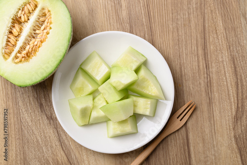 Piece of green melon fruit on plate ready to eating, Table top view