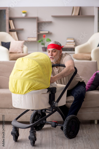 Old man looking after newborn at home © Elnur