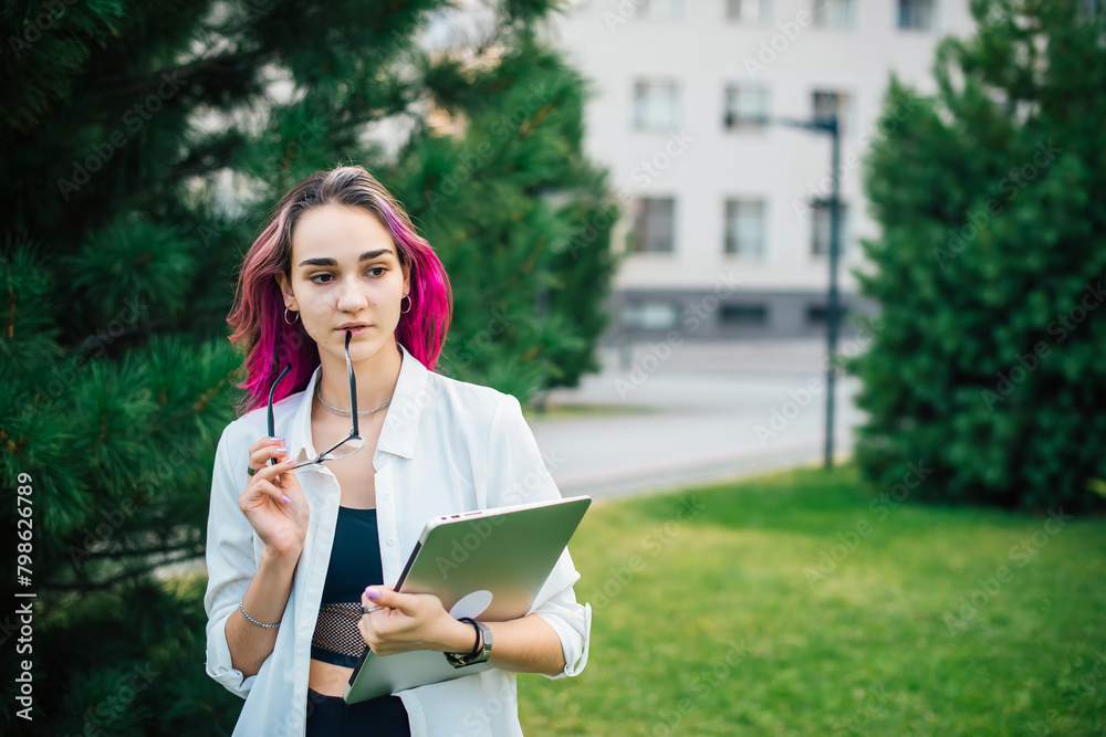 Obraz premium Portrait of young woman wearing glasses outdoors.