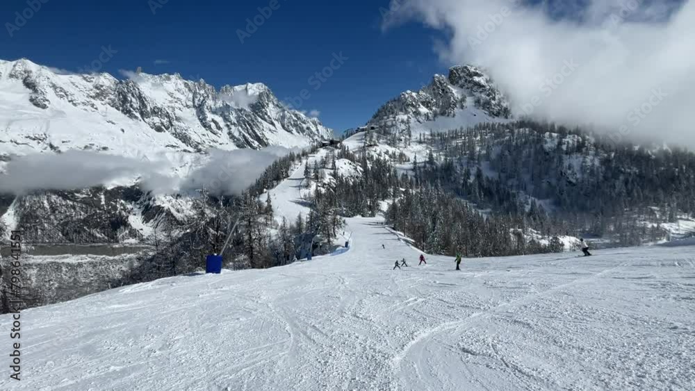 POV of a snowboarder or skier skiing down a well-beaten slope populated by other skiers with sunny Mont Blanc in the background - Active footage of an experienced professional snowboarder POV of a snowboarder or skier skiing down a well-beaten slope populated by other skiers with sunny Mont Blanc in the background - Active footage of an experienced professional snowboarder