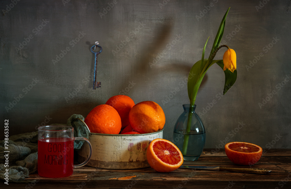 Still life with red oranges, a yellow tulip and a cup of freshly squeezed juice. Still life with red oranges, a yellow tulip and a cup of freshly squeezed juice.