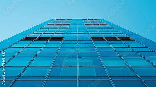  A towering structure with numerous windows along one side and a backdrop of azure sky