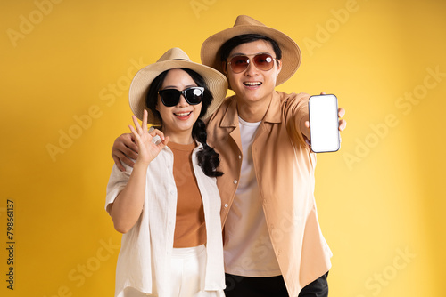 Portrait image of couple posing on yellow background, summer, travel