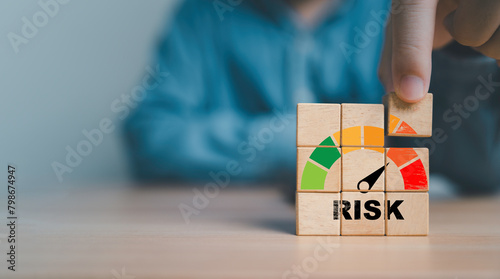Businessman assemble risk level indicator rating print screen wooden cube block since low to high with copy space for Risk management and assessment concept. photo