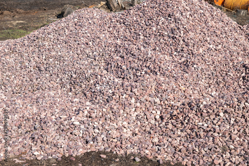 Crushed stone mound. Red crushed stones. Versatile building material for horticulture, landscape gardening or road construction. Material for railroad construction. photo