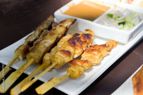 Chicken Satay with peanut sauce and pickles which are cucumber, chili and onions slices in vinegar.
