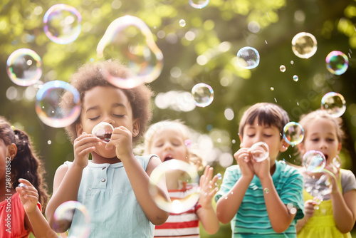 Group of children laughing while blowing bubbles in a sunlit garden