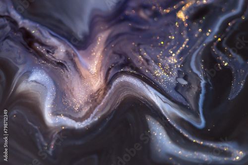 Blue and purple acrylic paints with golden glitter. Liquid paint abstract background. © smallredgirl