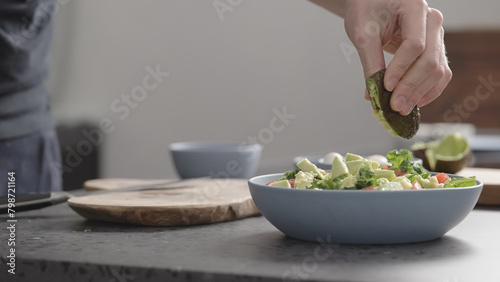 man make salad with kale, mozzarella, avocado and cherry tomatoes, cut avocado