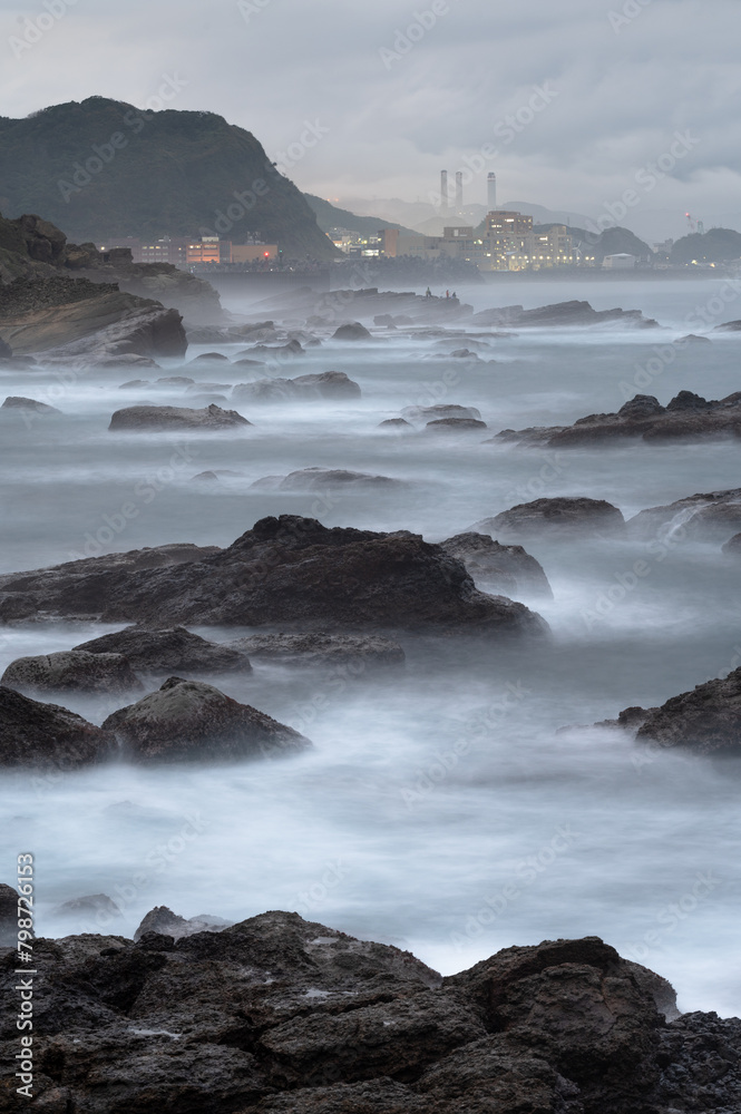 Long exposure of coastline with tide and rocks, like clouds flowing between it, in Keelung city, Taiwan.