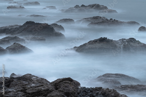Long exposure of coastline with tide and rocks, like clouds flowing between it, in Keelung city, Taiwan.