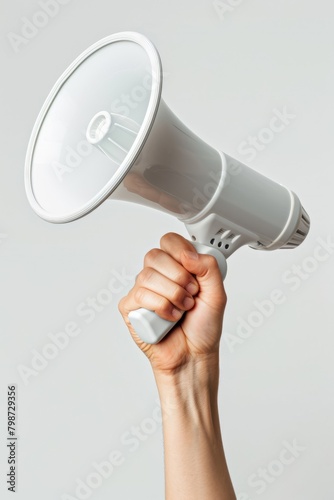 A hand holding a white megaphone on a white background. Copy space.
