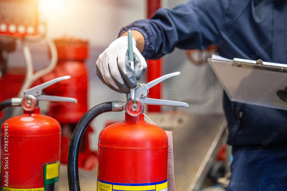Engineer are checking and inspection a fire extinguishers tank in the fire control room for safety training and fire prevention. Engineer are checking and inspection a fire extinguishers tank in the fire control room for safety training and fire prevention.