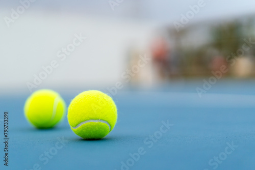 two tennis balls on blue tennis court, selective focus, copy space on right