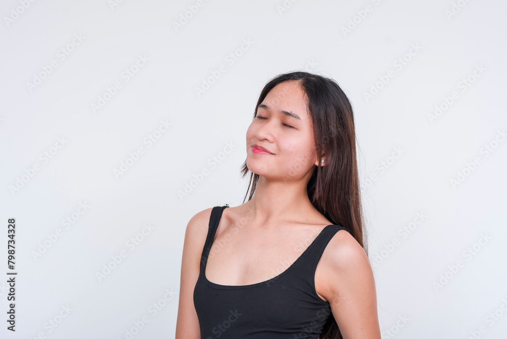 An image of a serene young Asian woman wearing a black bodysuit, isolated on a white backdrop, exuding a sense of bliss. An image of a serene young Asian woman wearing a black bodysuit, isolated on a white backdrop, exuding a sense of bliss.