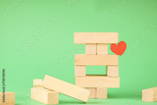 Wooden toy for building a tower from cubes. A heart among wooden cubes
