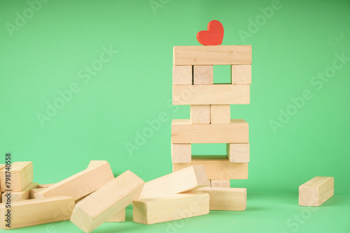 Wooden toy for building a tower from cubes. A heart among wooden cubes
