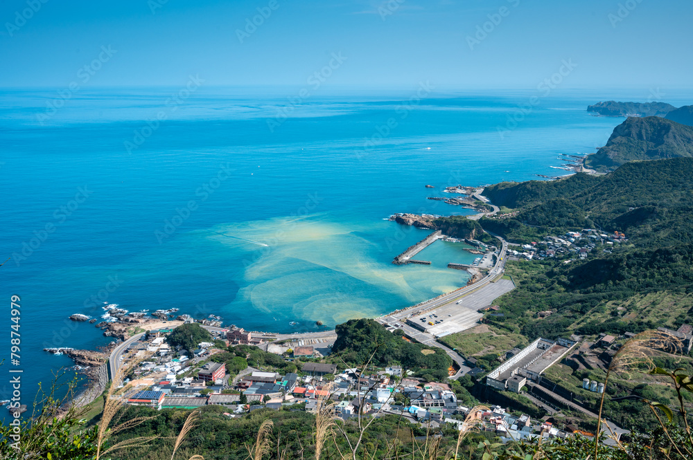 Overlook Yinyang Sea and small village of Shuinandong from the peak of Keelung mountain, golden river flow into the blue ocean, in Jinguashi, New Taipei City, Taiwan.